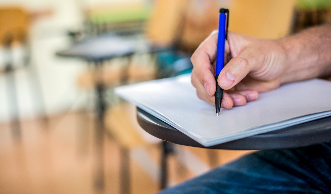 Persona escrivint en un bloc de notes durant una formació